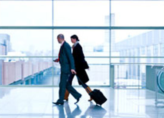 ein Bild von 2 Menschen mit einem Koffer im Flughafen
